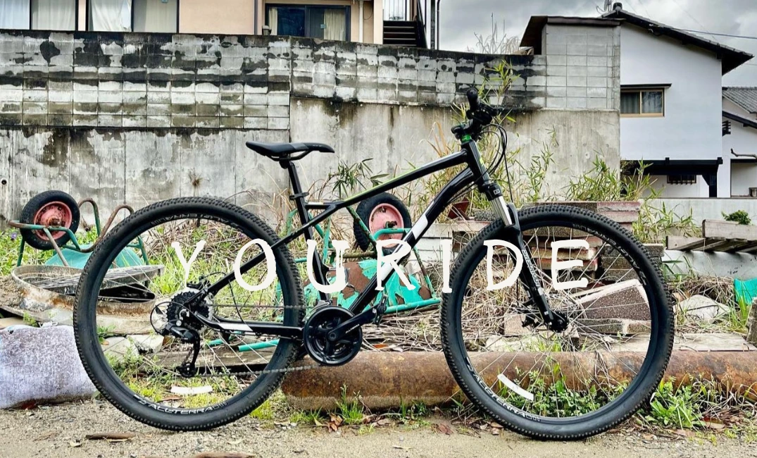 屋外に置かれた、白いYOURIDEロゴのある黒い自転車